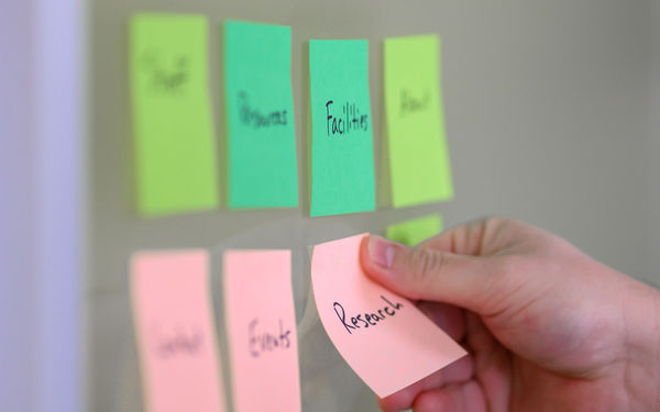 Two rows of four sticky notes labeled with sections of a site such as events, research, and facilities.